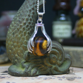 Spiritual necklace of two hands holding a Tiger Eye sphere