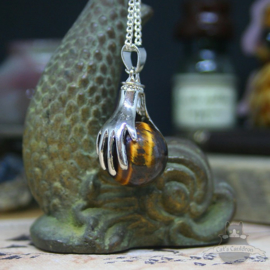 Spiritual necklace of two hands holding a Tiger Eye sphere