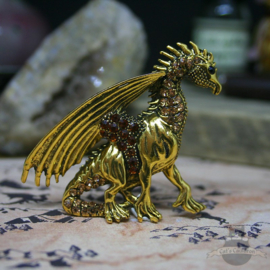 Gold colored dragon brooch decorated with stones