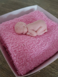 Baby zeep op een roze doekje