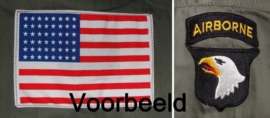 Het aanbrengen van 1 divisie patch & een armvlag op een jas