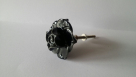 zwart kast- of deurknopje in roosvorm.