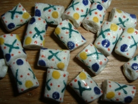 Mooie witte glaskralen met een patroontje in groen, geel en blauw.