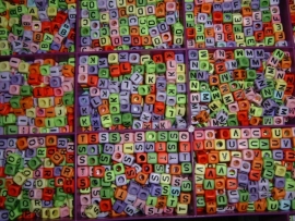 Mooie vrolijke gekleurde letterkralen in de vorm van een blokje