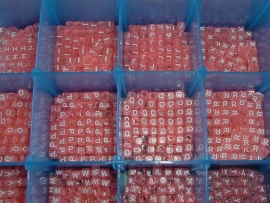 Mooie roze transparante letterkralen in de vorm van een blokje