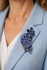 Blauw-zilverkleurige bladerenbroche met steentjes