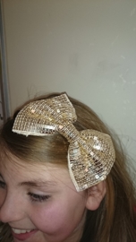 Leuke haarband met grote glitterstrik goud
