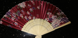 Mooie handwaaier met bloemen van bamboe en stof donkerrood