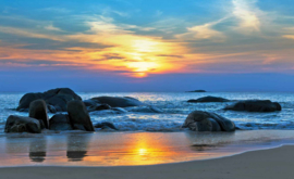 Fotobehang Zonsondergang Strand met Rotsen