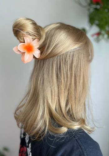 Bloerm oranje in het haar half opgestoken