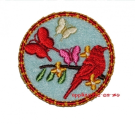 strijkapplicatie button met rode vogel en vlinder op licht blauw