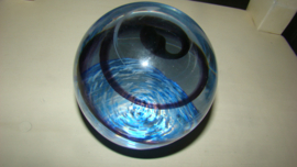 Grote presse-papier helder glas met zwarte spiraal en blauwe ondergrond.