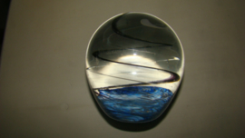 Grote presse-papier helder glas met zwarte spiraal en blauwe ondergrond.