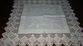 Vierkant wit geborduurd tafelkleedje met gehaakte rand.
