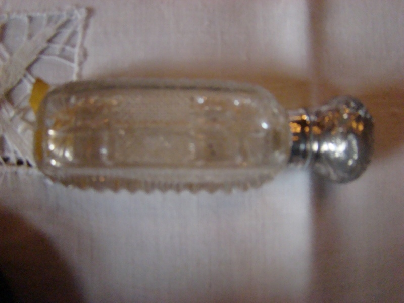 Geslepen parfumflesje met zilveren dop.