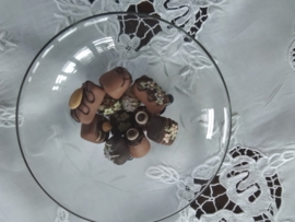 Kristallen bonbonschaaltje geslepen bloemtakje op drie zwart glazen pootjes.