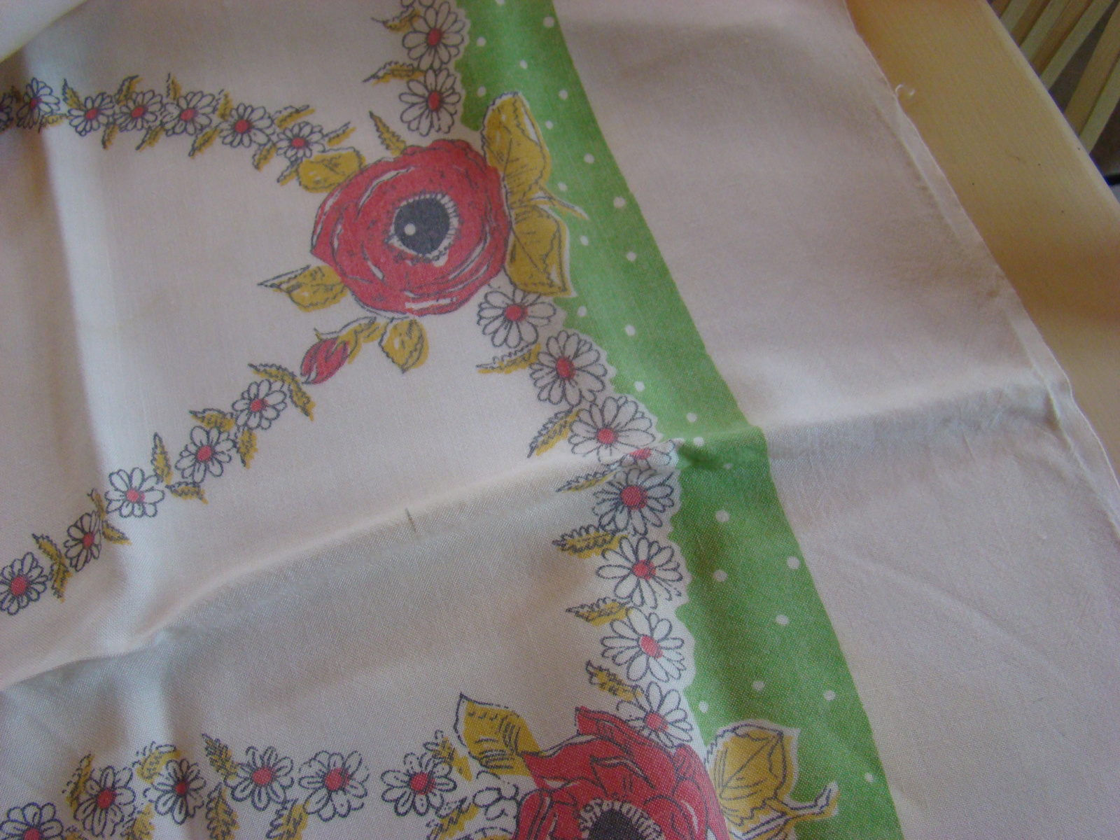 Vintage bedrukt kleed met rode rozen en groene blaadjes.