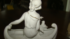 Wit biscuit beeldje ,meisje met vogeltje zittend op een bootje in vorm schelp.