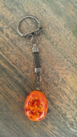 Oranje spikkelkraal aan bronskleurige sleutelhanger