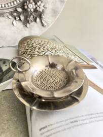 Old tea strainer with plate