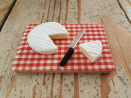 camembert kaas op plank met mes