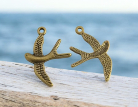 4 x Metalen bedel van een vogel zwaluw geel koperkleur afm. 31 x 22 x 2mm oogje: 2mm