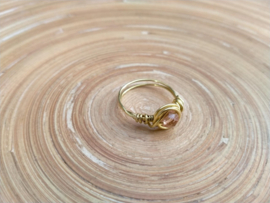 Copper wire ring in goudkleur met abrikooskleurige kraal. Ringmaat 20