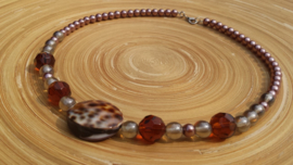 Korte bruin geregen glasparel ketting met grote schelpkraal