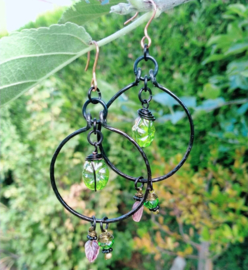 Zwarte oorbellen met groene electroplated bloemkralen
