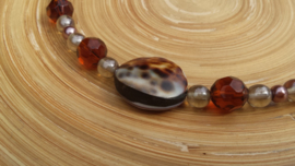 Korte bruin geregen glasparel ketting met grote schelpkraal