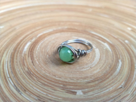 Zilverkleurige ring met lichtgroene facet geslepen glasparel. Ringmaat 16.5