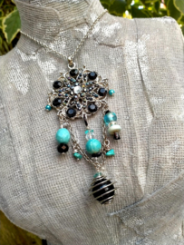 Korte zwart en turquoise ketting met ornament aan fijn jasseron
