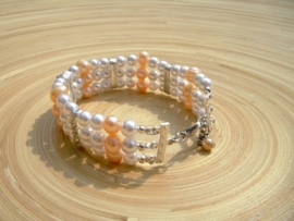 Zalmkleurige armband van glas- en zoetwaterparels en strass verdelers