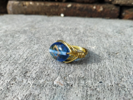 Goudkleurig copper wire ring met grote kobaltblauwe glaskraal. Ringmaat 17