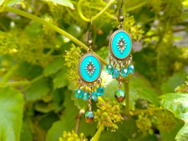 Turquoise/bruine oorbellen met glas bicones