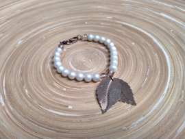 Roomwitte armband met mat gespoten glasparels en roségouden blad bedels