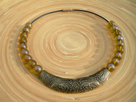 Spang ketting van grote glasparels en een bronskleurig ornament