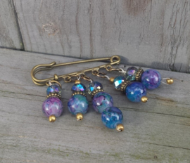 Bronskleurige dasspeld of kiltspeld met blauw en lila glasparels