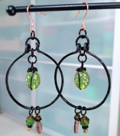Zwarte oorbellen met groene electroplated bloemkralen