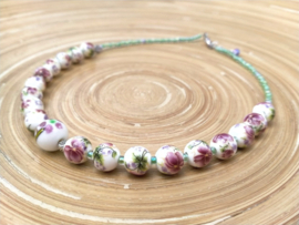 Korte bloemenketting van keramiek in wit, roze en groen