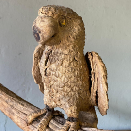 Unique hand-carved wooden parrot on a branch