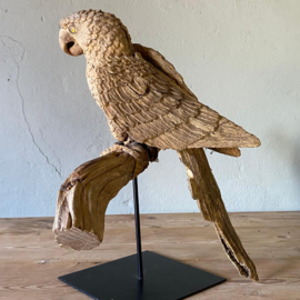 Unique hand-carved wooden parrot on a branch