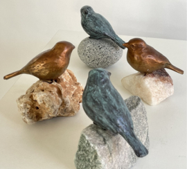 Bronzen vogeltje op steen