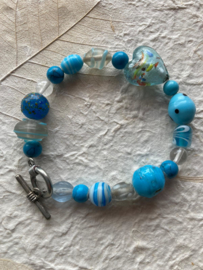 Glaskralen armband met blauw en turquoise  kralen, hartje en met slotje