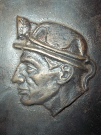 Bronze plaque of a miner wearing his typical helmet.Bronzen plaquette van een mijnwerker met zijn helm.