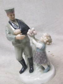 German statue made of china, nicely marked. Porseleinen beeld ( vaas) van een Duitse soldaat die gewond uit de Eerste Wereldoorlog terug komt en bloemen krijgt overhandigd. genummerd en gemerkt Zeldzaam stuk. TOP 19 cm..