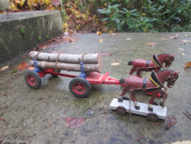 2 paarden met kar met boomstammen.