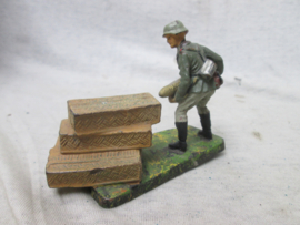Elastolin soldaatje met artillerie kogel en manden. Duits.