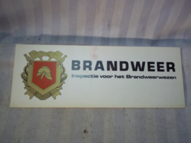 Bordje BRANDWEER inspectie voor het brandwezen met embleem, werd in de auto voor het raam gelegd.