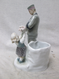 German statue made of china, nicely marked. Porseleinen beeld ( vaas) van een Duitse soldaat die gewond uit de Eerste Wereldoorlog terug komt en bloemen krijgt overhandigd. genummerd en gemerkt Zeldzaam stuk. TOP 19 cm..